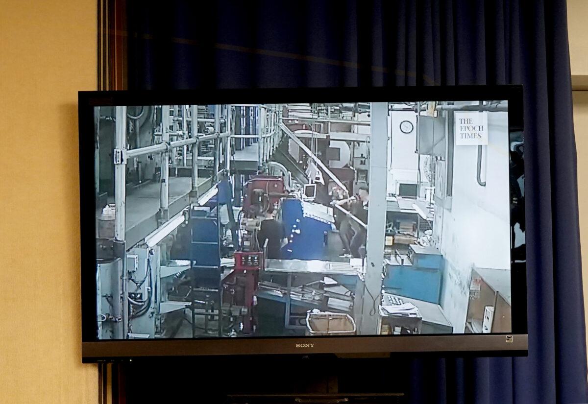 A screen shows footage of the attack on the printing press of the Hong Kong edition of The Epoch Times, during a press conference at the National Press Club in Washington on April 13, 2021. (Jenny Jing/Epoch Times)