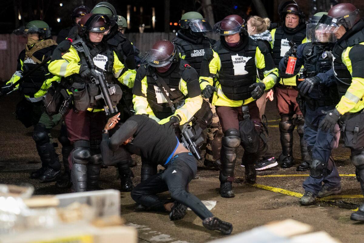 A demonstrator is arrested by police for violating curfew and an order to disperse during civil unrest in Brooklyn Center, Minn., on April 12, 2021. (John Minchillo/AP Photo)