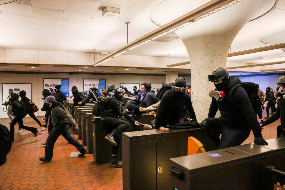 People illegally jump over turnstiles at the Gallery Place metro station during civil unrest following the fatal police shooting of 20-year-old black man Daunte Wright, in Washington on April 12, 2021. (Evelyn Hockstein/Reuters)