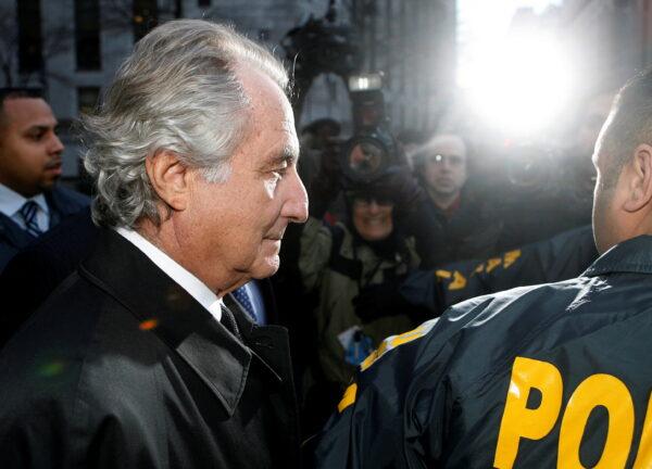 Disgraced financier Bernard Madoff is escorted by police and photographed by the media as he departs Federal Court after a hearing in New York City, on Jan.5, 2009. (Lucas Jackson/Reuters)