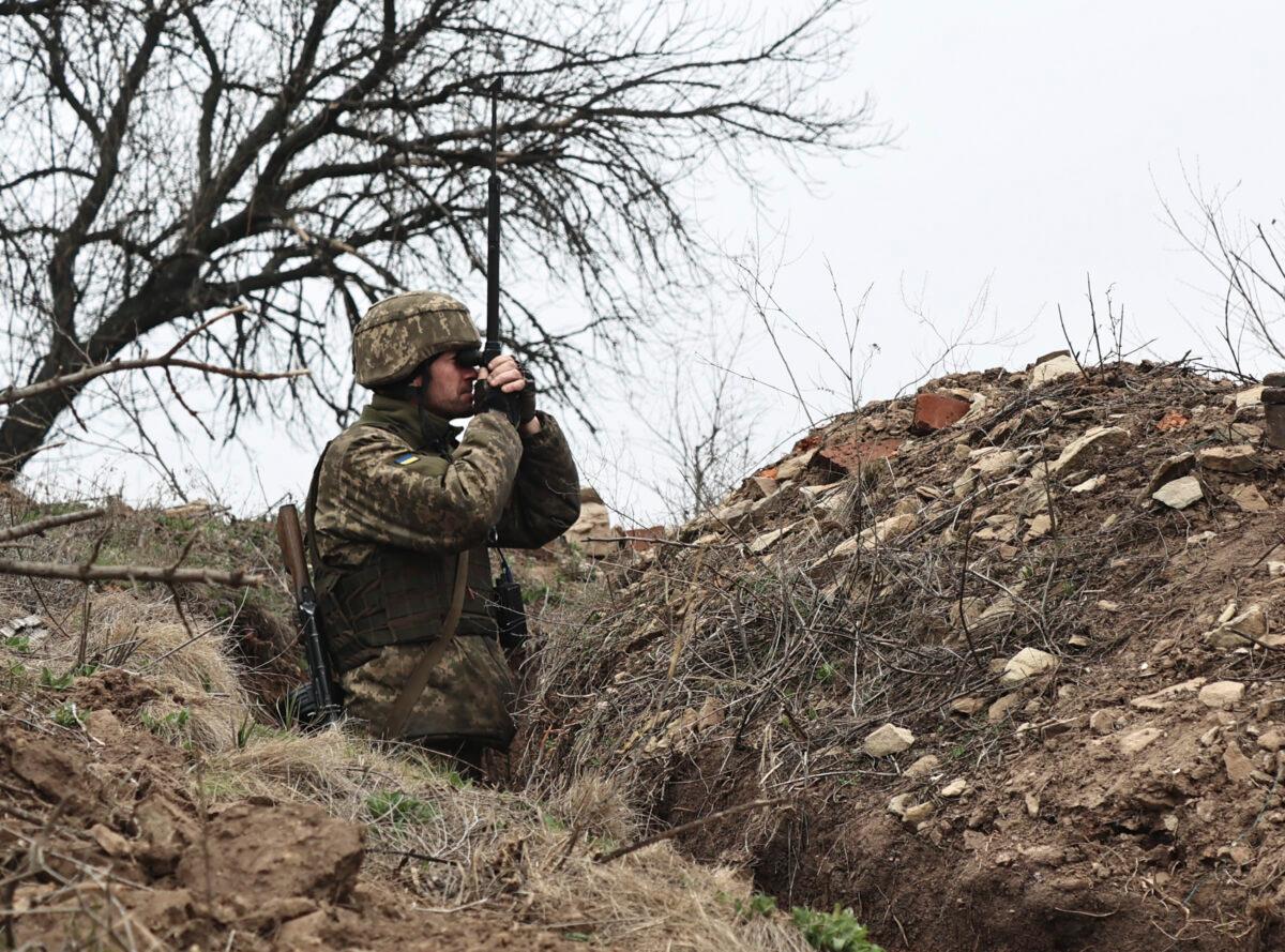 A Ukrainian soldier watches through a periscope at fighting positions on the line of separation from pro-Russian rebels near Donetsk, Ukraine, on April 12, 2021 (AP Photo/File)