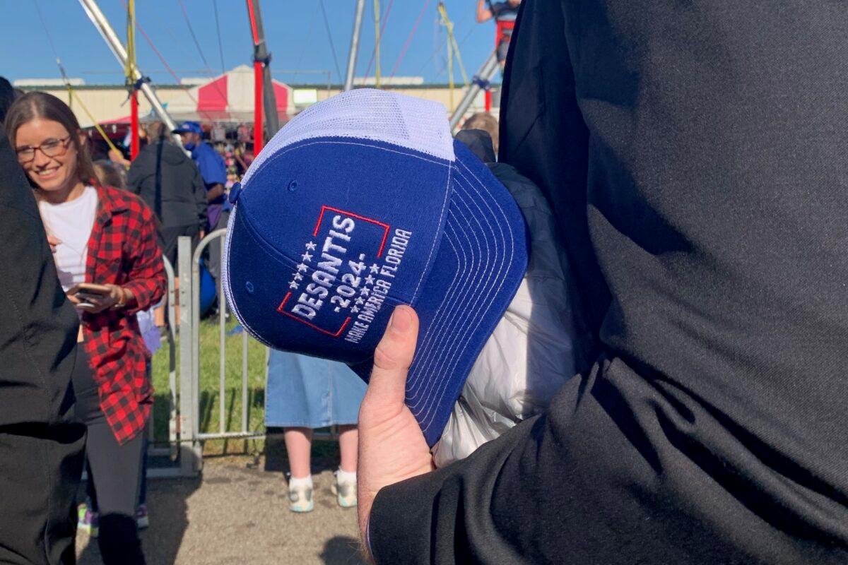 A staff member for Gov. Ron DeSantis holds a "DeSantis 2024, Make America Florida" hat at the Clay County fair on April 1, 2021. The staff member said the hat was handed to the governor by a fair attendee. (Ivan Pentchoukov/Epoch Times)