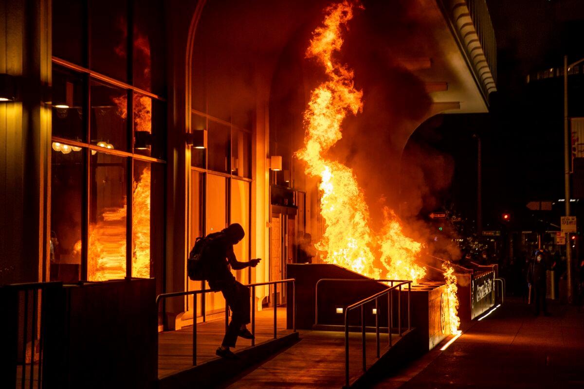 Rioters set fire to the California Bank and Trust building in Oakland, Calif., on April 16, 2021. (Ethan Swope/AP Photo)