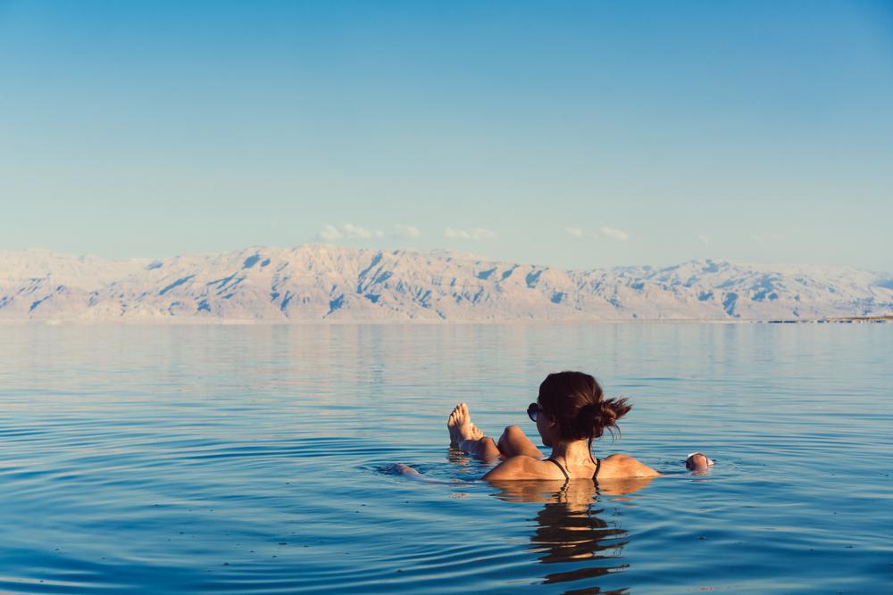 A woman relaxes in the water of the Dead Sea. (Hrecheniuk Oleksii/Shutterstock)
