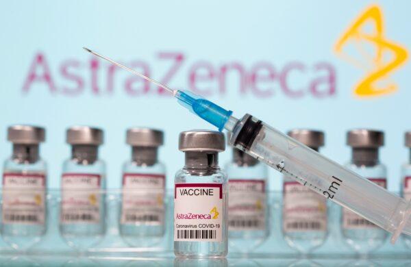 Vials labelled "AstraZeneca COVID-19 Coronavirus Vaccine", and a syringe are seen in front of a displayed AstraZeneca logo in this illustration taken March 10, 2021. (Dado Ruvic/Illustration/Reuters)