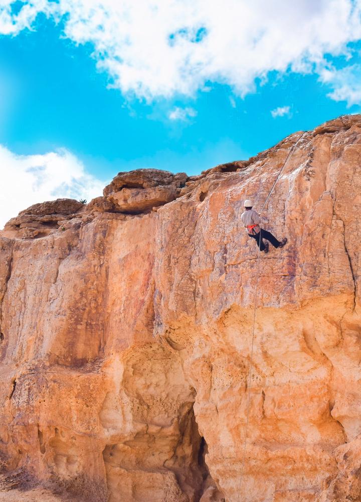 A climber rappels down a cliff at the Mitzpe Ramon crater. (Antonio Rico/Shutterstock)
