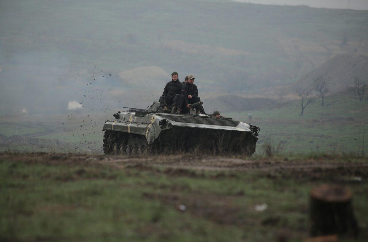 Service members of the Ukrainian armed forces drive an armored vehicle during training at a firing range in the Donetsk region, Ukraine, on April 20, 2021. (Serhiy Takhmazov/Reuters)