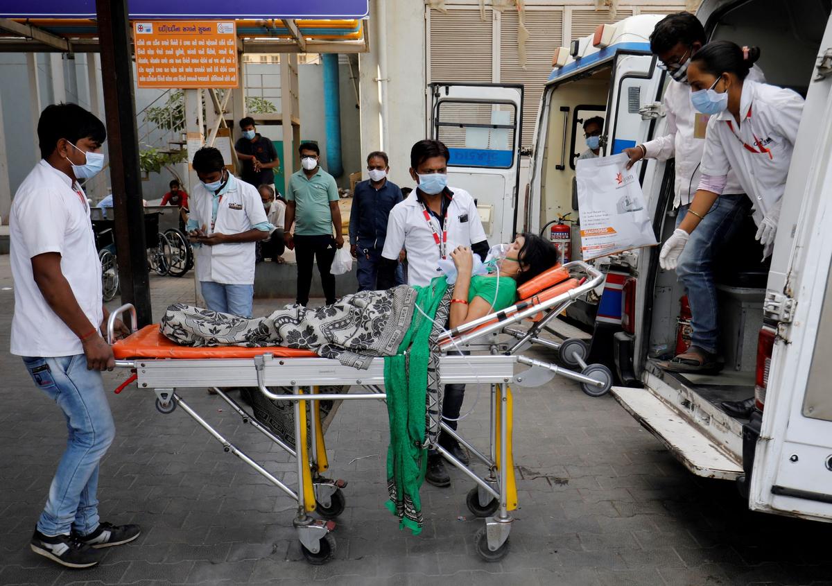 A patient wearing an oxygen mask is wheeled inside a COVID-19 hospital for treatment in Ahmedabad, India, on April 21, 2021. (Amit Dave/Reuters)
