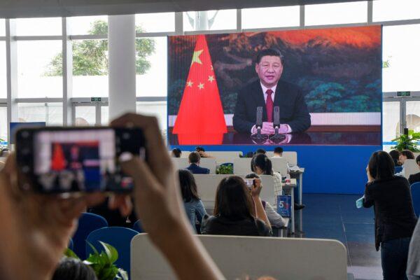 Journalists watch a screen showing  Xi Jinping delivering a speech during the opening of the Boao Forum for Asia (BFA) Annual Conference 2021 in Boao, Hainan Province, China, on April 20, 2021. (STR/AFP via Getty Images)