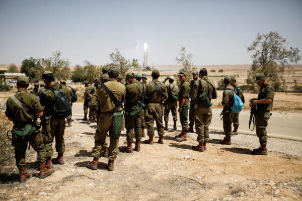 Israeli soldiers gather as they survey the area after a Syrian missile exploded in southern Israel, the Israeli military said, in Ashalim, southern Israel, on April 22, 2021. (Amir Cohen/Reuters)