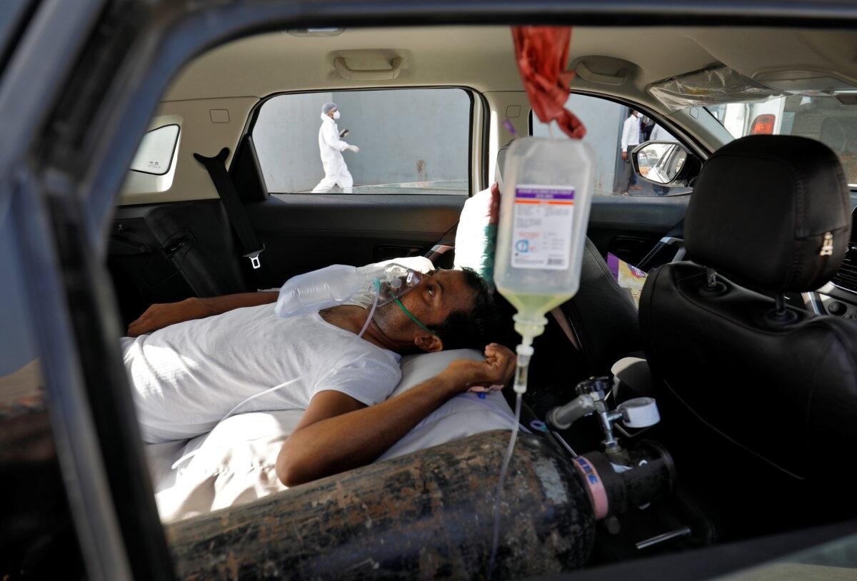 A patient with breathing problems is seen inside a car while waiting to enter a COVID-19 hospital for treatment, amidst the spread of the coronavirus disease in Ahmedabad, India, on April 22, 2021. (Amit Dave/Reuters)