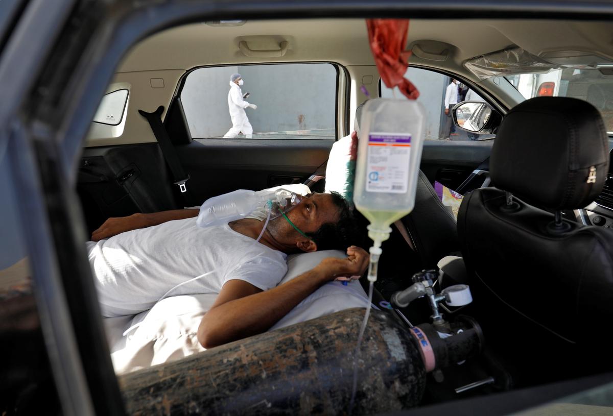 A patient with breathing problems is seen inside a car while waiting to enter a COVID-19 hospital for treatment, amid the spread of the disease in Ahmedabad, India, on April 22, 2021. (Amit Dave/Reuters)
