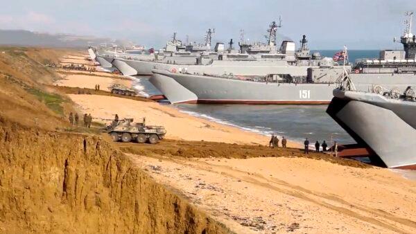 This handout photo taken from a video released by Russian Defense Ministry Press Service shows, Russian troops board landing vessels after drills in Crimea on Friday, April 23, 2021. (Russian Defense Ministry Press Service via AP)