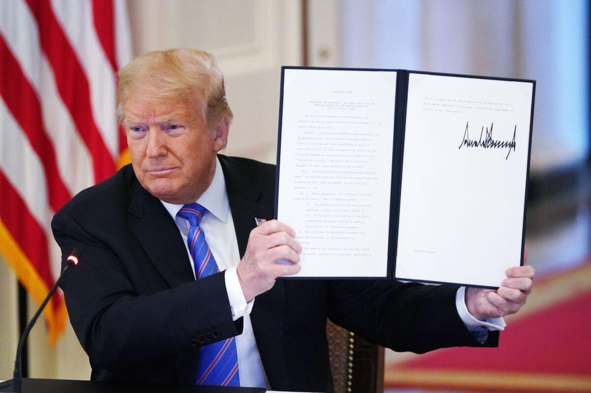 President Donald Trump holds an executive order he signed at the White House in Washington on June 26, 2020, to establish a 20-person Advisory 1776 Commission under the Department of Education to promote “patriotic education.” The commission was terminated by President Joe Biden on Jan. 20, 2021. (Mandel Ngan/AFP via Getty Images)