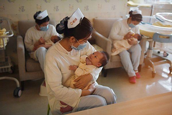Nurses hold babies at the Xiyuege Center, or "Lucky Month Home," in Beijing, on Dec. 13, 2016. (Greg Baker/AFP via Getty Images)
