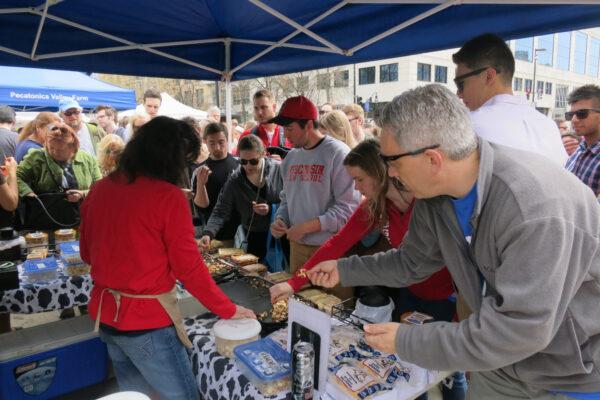 The cheese-stabbing masses huddled around the Brunkow Cheese tent at the Dane County Farmers Market. (Kevin Revolinski)