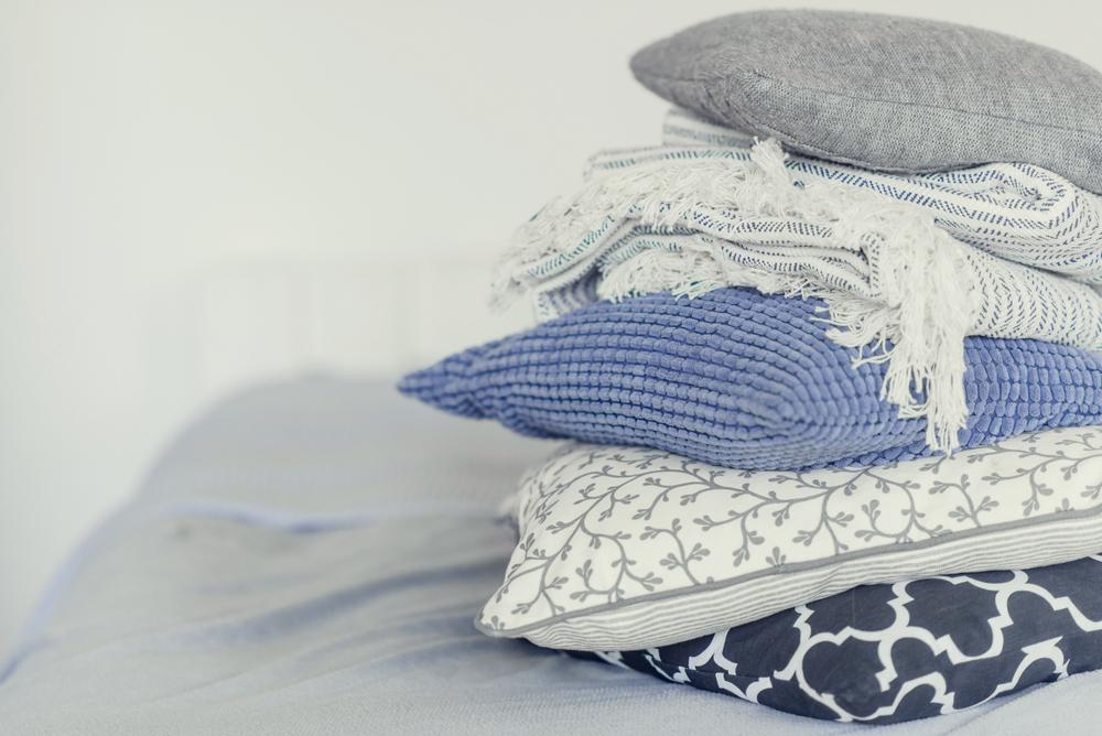 Clean textiles you may not wash regularly, such as curtains, throw pillows, and blankets. (Malykalexa/Shutterstock)