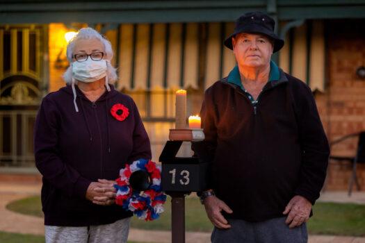 Shirley Lane and Terry Ovens pay their respects during a driveway dawn service at their Huntingdale home in Perth, Australia on April 25, 2021. Anzac Day services were cancelled following the announcement of a three-day lockdown. (Paul Kane/Getty Images)