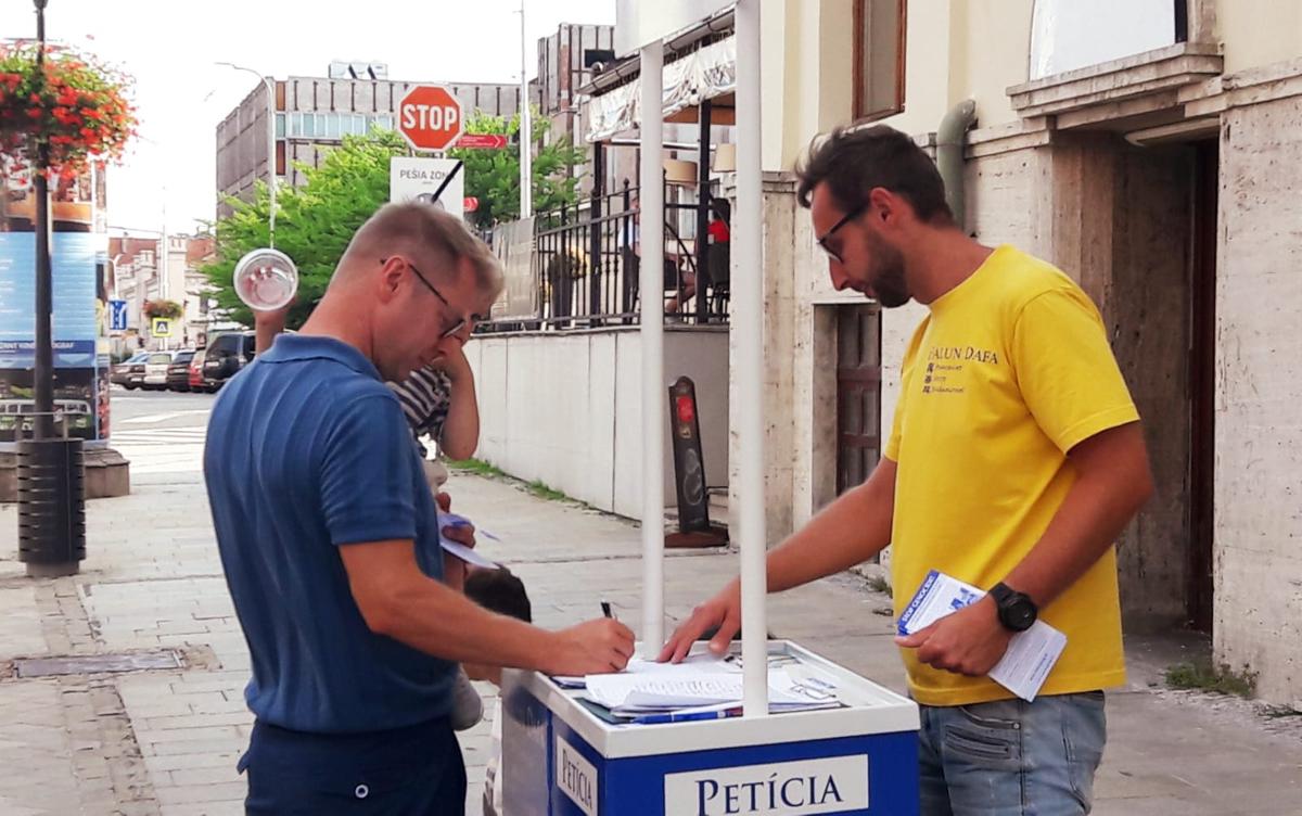 Erik Fehér (R), 39, a teacher from Slovakia, collecting signatures for calling an end to the CCP's atrocities of forced organ harvesting and persecution of Falun Gong. (Courtesy of Erik Fehér)