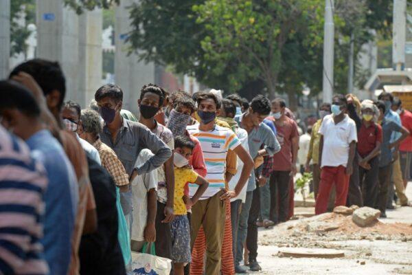 People stand in a queue to receive free food being distributed by a Hindu voluntary organisation amid the COVID-19 coronavirus pandemic in Hyderabad on April 26, 2021. (Noah Seelam/Getty Images)