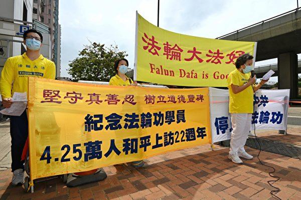 Four Falun Gong practitioners in front of the Liaison Office in Hong Kong on April 25, 2021, to commemorate the 22nd anniversary of a historical appeal for freedom of belief in mainland China. (Song Bilong/The Epoch Times)