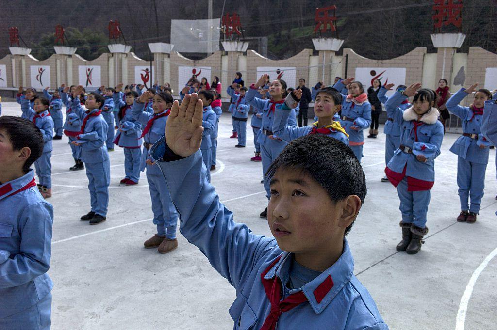 Children dressed in uniform sing after raising China's national flag at the Beichuan "Red army" elementary school in Beichuan, in Sichuan Province, on Jan. 21, 2015. (Fred Dufour/AFP via Getty Images)