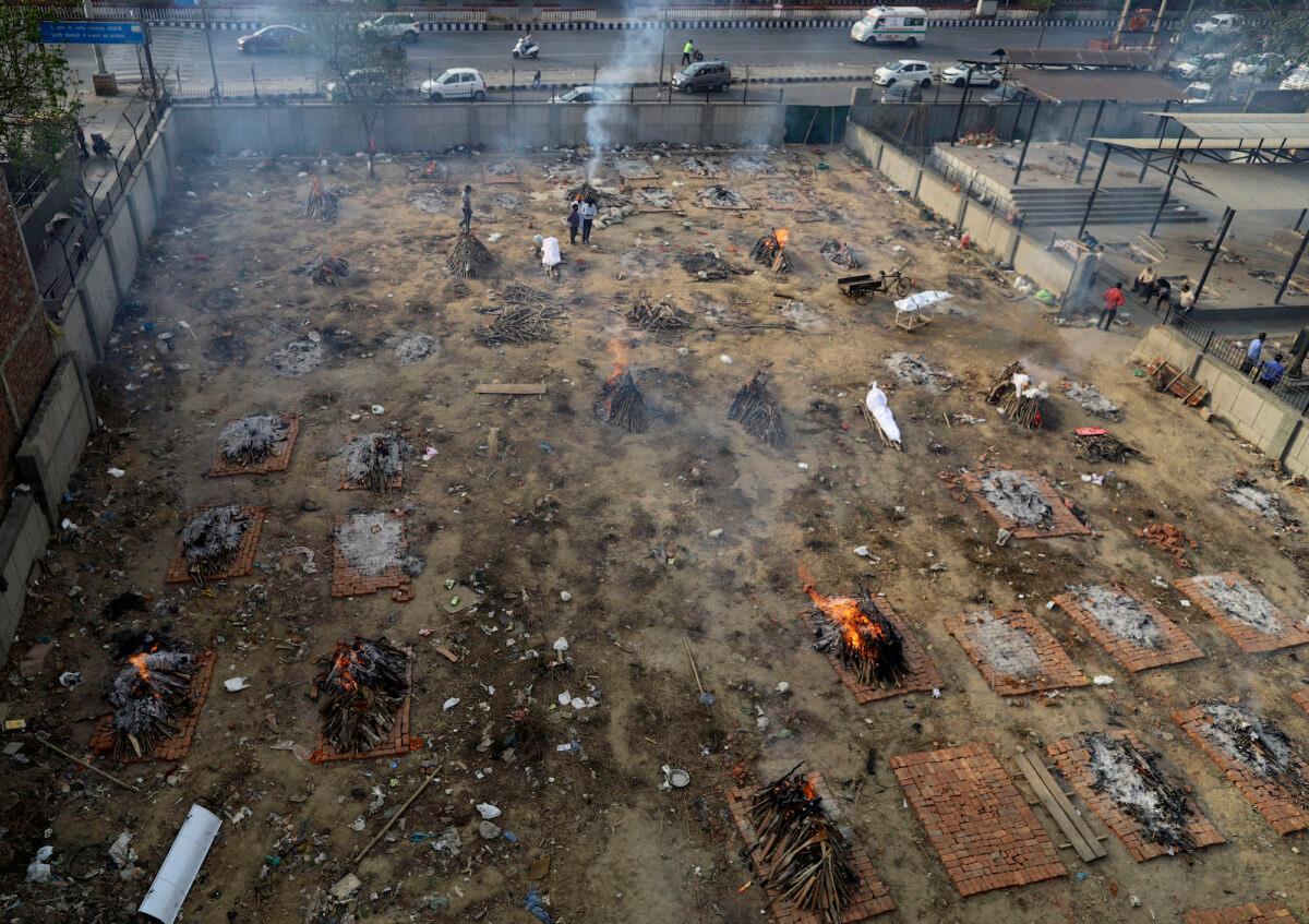 Multiple funeral pyres of patients who died of COVID-19 are seen burning at a makeshift crematorium in New Delhi, on April 21, 2021. (Amarjeet Kumar Singh/AP)