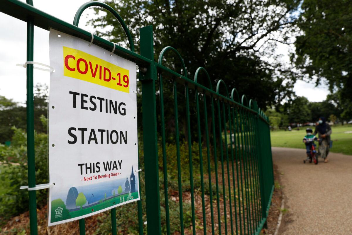 People walk past a sign directing to a walk-in mobile COVID-19 testing centre in Spinney Hill Park in Leicester, England, on June 28, 2020. (Darren Staples/Getty Images)