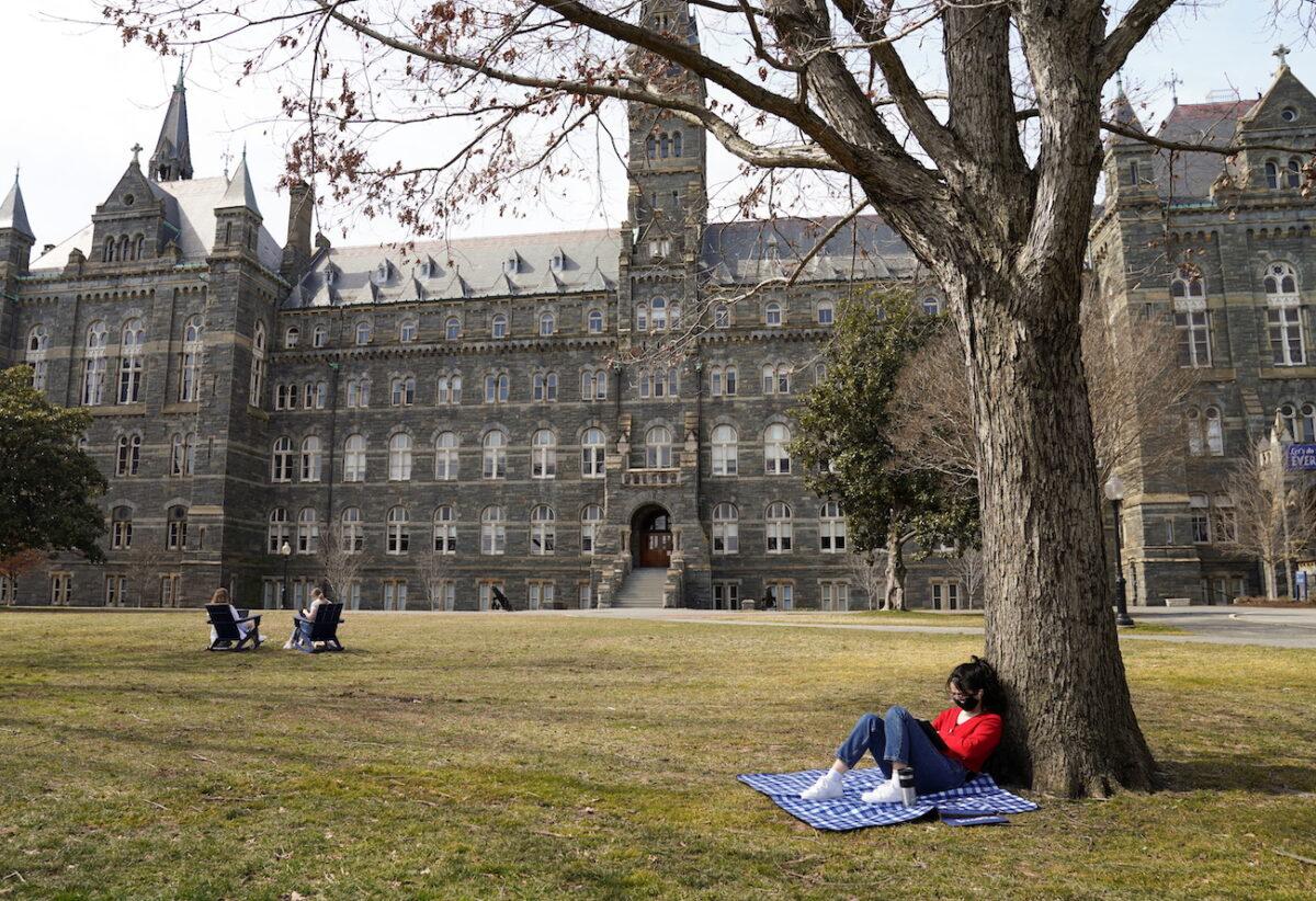 A student studies in the sunshine at Georgetown University in Washington on March 9, 2021. (Kevin Lamarque/Reuters)