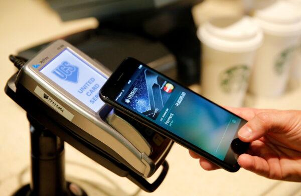 A man uses an iPhone 7 smartphone to demonstrate the mobile payment service Apple Pay at a cafe in Moscow, Russia, on Oct. 3, 2016. (Maxim Zmeyev/Reuters)