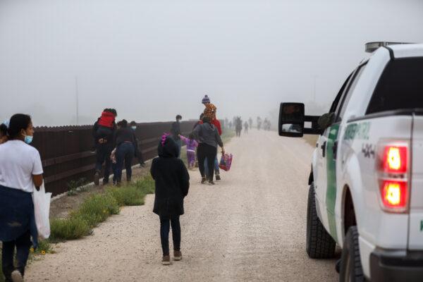 A group of illegal immigrants with Border Patrol after crossing the U.S.–Mexico border in La Joya, Texas, on April 10, 2021. (Charlotte Cuthbertson/The Epoch Times)