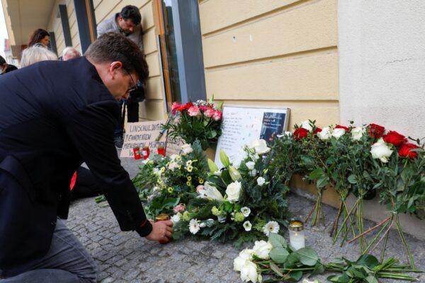 Director of the Association of Deaf people in Berlin & Brandenburg Steffen Helbing puts a candle at a makeshift altar outside the Oberlin Clinic in Potsdam, Germany on April 29, 2021. (Michele Tantussi/Reuters)