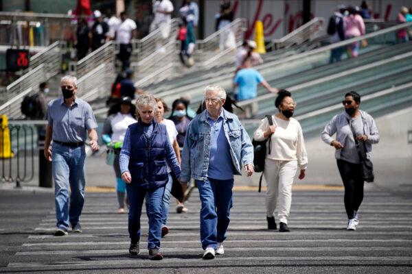 Masked and unmasked pedestrians walk across Las Vegas Boulevard, in Las Vegas, Nev., on April 27, 2021. (John Locher/AP Photo)