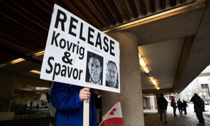 A man holds a sign calling for the release of Michael Kovrig and Michael Spavor outside B.C. Supreme Court where Huawei chief financial officer Meng Wanzhou was attending a hearing, in Vancouver, Canada, on Jan. 21, 2020. (Darryl Dyck/The Canadian Press)