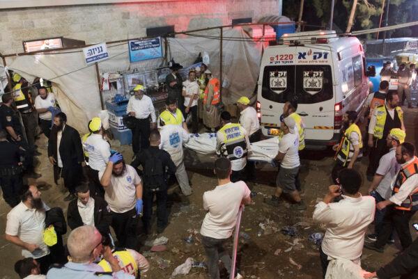 Israeli security officials and rescuers carry a body of a victim who died during a Lag Ba'Omer celebrations at Mt. Meron in northern Israel, on April 30, 2021. (AP Photo)