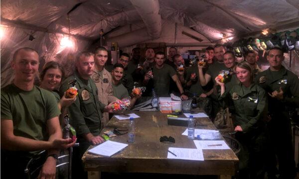 U.S. soldiers serving overseas hold up items received in care packages sent by former Marine Si Tenenberg. (Courtesy of Si Tenenberg)