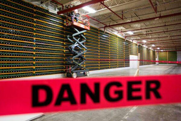 Two construction workers use a lift along a wall of bitcoin mining at Bitfarms in Saint Hyacinthe, Quebec, on March 19, 2018. Bitcoin is a cryptocurrency and worldwide payment system. It is the first decentralized digital currency, as the system works based on blockchain technology without a central bank or single administrator. (Lars Hagberg/AFP via Getty Images)