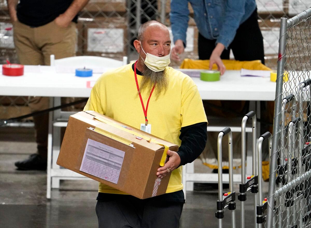 A box of ballots cast in the 2020 election is delivered to be examined and recounted by contractors working for Florida-based company, Cyber Ninjas, who was hired by the Arizona Senate, at Veterans Memorial Coliseum in Phoenix, Ariz., on April 29, 2021. (Rob Schumacher/The Arizona Republic via AP/Pool)