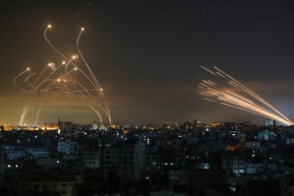 The Israeli Iron Dome missile defence system (L) intercepts rockets (R) fired by the Hamas movement towards southern Israel from Beit Lahia in the northern Gaza Strip as seen in the sky above the Gaza Strip overnight on May 14, 2021. (Anas Baba/AFP via Getty Images)