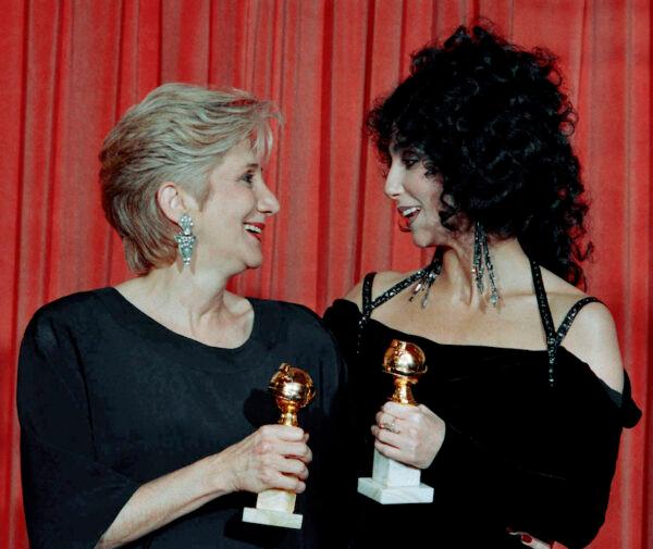 Actress Olympia Dukakis, winner of a Golden Globe for "Best Performance in a Supporting Role" and Cher, winner of the "Best Performance by an Actress in a musical or comedy", hold the awards they received for performances in the hit movie "Moonstruck" during the Foreign Press Awards at the Beverly Hilton Hotel, on Jan. 24, 1988. (Reed Saxon/AP)