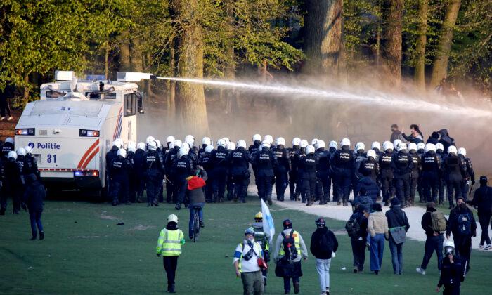 Police use a water cannon against protestors at the Bois de la Cambre park during a party called "La Boum 2" in Brussels, on May 1, 2021. (Olivier Matthys/AP Photo)