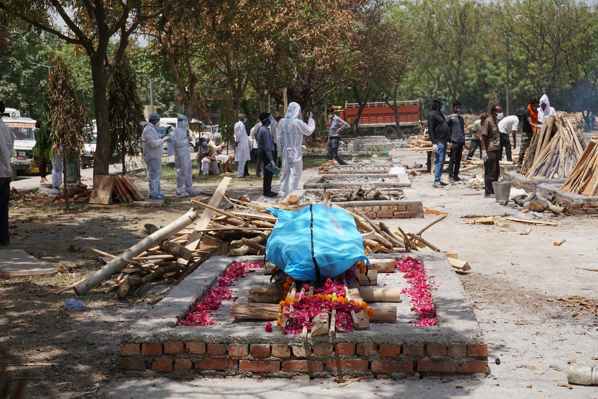 Madhav Swaroop, 89, father of a leading corporate executive died due to COVID and age-related complications 3 days after testing positive for COVID. In this picture, Swaroop's body is laid on a flower-decked pyre before being offered the customary wood on the afternoon of May 4, 2021, at the lawns of Sare Kale Khan crematorium in the outskirts of New Delhi. (Venus Upadhayaya/The Epoch Times)