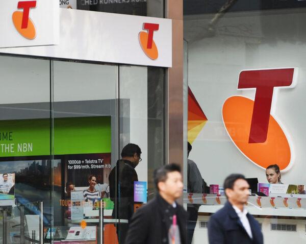 A Telstra logo is seen as pedestrians walk outside the Telstra Melbourne headquarters in Melbourne, Australia, on June 14, 2017 (Michael Dodge/Getty Images)
