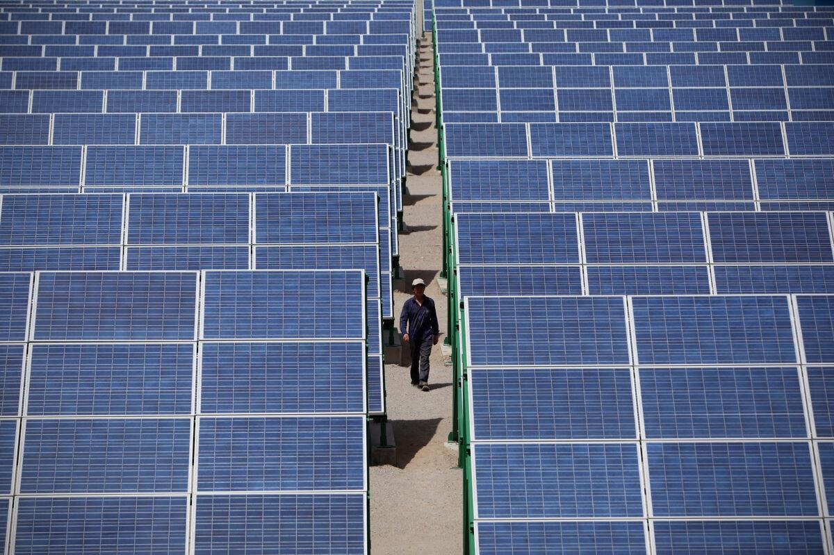 A Chinese worker walks in the solar modules of a newly installed 100 MW photovoltaic on-grid power project in Dunhuang, in China's Gansu Province on July 21, 2010. (Feng Li/Getty Images)