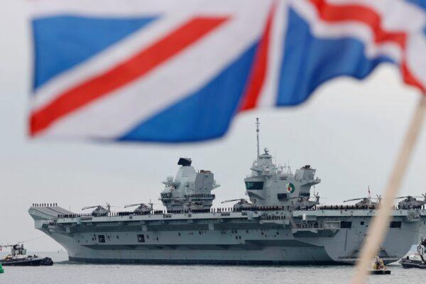 The HMS Queen Elizabeth aircraft carrier leaves Portsmouth Naval Base on the south coast of England on May 1, 2021. The carrier will take part in exercises off Scotland before heading to the Indo-Pacific region for her first operational deployment. (Adrian Dennis/AFP via Getty Images)