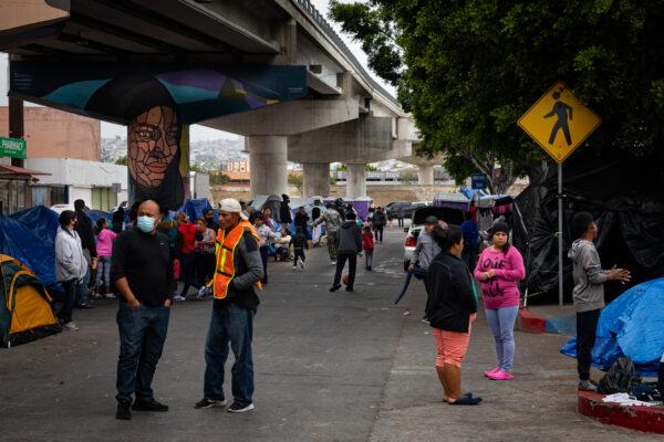 Migrants wait at a tent encampment under a freeway in Tijuana, Mexico, on April 22, 2021. (John Fredricks/The Epoch Times)