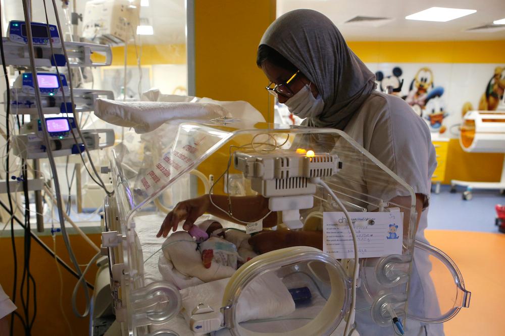  A Moroccan nurse takes care of one of the nine babies protected in an incubator at the maternity ward of the private clinic of Ain Borja in Casablanca, Morocco. (Abdeljalil Bounhar/AP Photo)