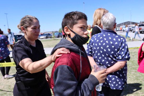 Adela Rodriguez, left, walks with her son, Yandel Rodriguez, 12, at the high school where people were evacuated after a shooting at the nearby Rigby Middle School earlier in Rigby, Idaho on May 6, 2021. (AP Photo/Natalie Behring)