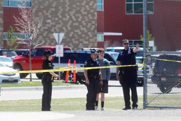 Police stand with a youth outside Rigby Middle School following a shooting there, in Rigby, Idaho, on May 6, 2021. (AP Photo/Natalie Behring)