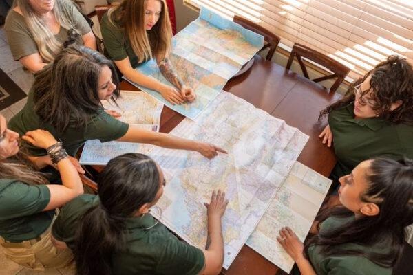 Members of Mamalitia, a women's group that promotes self-reliance and survival skills, point to a map in California. (Courtesy of Mamalitia)